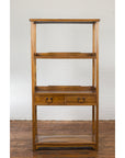 Light wood three-shelf bookcase with two drawers, positioned against a plain white wall.