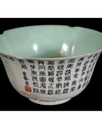 Blue-green porcelain bowl with black calligraphy on exterior and red seal mark, close-up.
