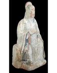 Terracotta Ming Dynasty court figure statuette in faded robes and headdress on black background, 17th century.