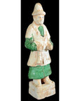 Terracotta Ming Dynasty figure with conical hat, green pants, and white tunic, close-up view.