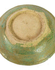 Close-up of greenish glazed ceramic Ming Dynasty plate with unglazed foot, antique Chinese dish style.
