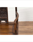 Close-up of brown elmwood Ming Dynasty chair with carved animal design on the backrest.