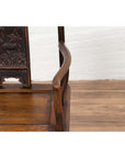 Close-up of brown elmwood Ming Dynasty chair with carved animal design on the backrest.