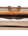 Close-up of brown elmwood Ming Dynasty chair with ornate wood grain and carved decorative edge.