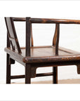 Close-up of brown elmwood Ming Dynasty style chair with curved backrest and armrests on white background.