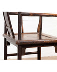 Close-up of brown elmwood Ming Dynasty style chair with curved backrest and armrests on white background.