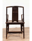 Brown elmwood chair with curved backrest on wooden floor, front view.