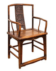 Brown elmwood chair with carved backrest and curved armrests, Ming Dynasty style, photographed indoors.