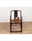 Brown elmwood Ming Dynasty Chinese wedding chair on wood floor indoors.