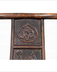 Close-up of brown elmwood Chinese Ming Dynasty chair with carved floral patterns, white background.