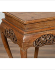 Close-up of a dark wood Ming style incense stand with cabriole legs and carved apron, on a wooden floor indoors.