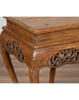 Close-up of a dark wood Ming style incense stand with cabriole legs and carved apron, on a wooden floor indoors.
