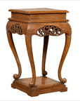 Brown wood Ming style incense stand with cabriole legs, carved apron, square top and base, shown on plain background.