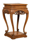 Brown wood Ming style incense stand with cabriole legs, carved apron, square top and base, shown on plain background.