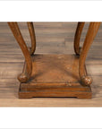 Close-up of brown wooden Chinese Ming style incense stand with cabriole legs and carved apron on wood floor.