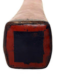 Close-up of red lacquer tip on square end of Chinese opium pillow, ceramic, against white background.