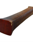Brown wooden opium pillow with flat rectangular top and bottom, curved textured center, close-up.