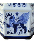 Close-up of blue and white porcelain bottle with lion and cloud designs on an octagonal surface.