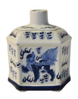 Close-up of blue and white painted ceramic bottle, hexagonal shape with mythical creature and swirling cloud motifs.