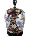 Black base Chinese porcelain electric lamp with floral designs, shown in overall good condition; may need rewiring.
