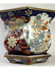 Close-up of blue, red, and gold floral Chinese porcelain planter on matching base.