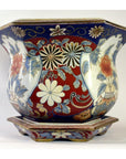 Red, blue, and white Chinese porcelain planter with hand-painted floral patterns on a matching base.
