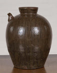 Glazed ceramic water jug with petite spout and rounded body, Qing Dynasty, 19th century, on plain background.