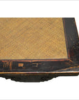 Close-up of dark wood Chinese rattan coffee table with visible scratches on frame and rattan inset.