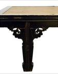 Dark wood and cane rattan coffee table with ornate legs, rectangular inset, on white background.