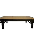 Brown rattan coffee table with carved corners, set against a plain white background.