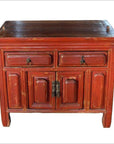 Chinese red lacquer wood side cabinet with two drawers, two doors, and metal handles in a distressed finish.