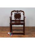 Dark rosewood Chinese chair with carved backrest, 19th century, on wooden floor next to color chart.