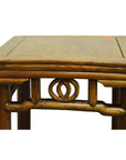 Close-up of a wooden Chinese side table with carved friezes beneath the tabletop.