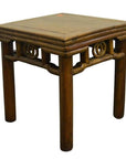 Brown wooden Chinese side table with carved friezes under the tabletop, four legs, close-up view.