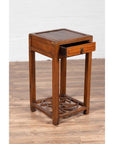 Brown elmwood lamp table with single drawer and cracked ice shelf on a wooden floor.