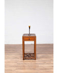 Brown elmwood table with single drawer and cracked ice shelf, tall candle holder with candle on top.