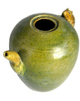 Close-up of green-glazed ceramic Chinese water dropper with spout and animal-shaped handle, missing top.