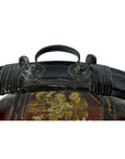 Close-up of ornate black metal handle on Chinese wedding basket with gold and red painted decorative figures below.