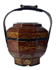 Close-up of brown wooden hexagonal Chinese wedding basket with ornate gold patterns and curved black handle.