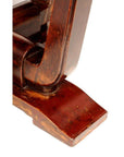 Close-up of reddish-brown Elmwood leg of circular side table showing wood grain and joinery details.