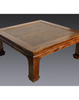 Light rattan coffee table with lacquer finish and curved legs on a gray background.