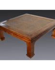Light lacquered wood square coffee table with raised edge and sturdy curved legs, studio view.