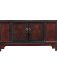 Red and black wooden coffee table with floral designs, two central doors, and lacquer accents, close-up view.