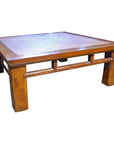 Natural rattan coffee table with thick legs and recessed tabletop, sturdy design, close-up view.