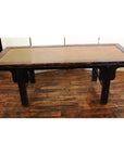 Brown wooden coffee table with woven rattan top on a wooden floor in an indoor room setting.