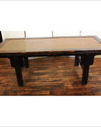 Brown wooden coffee table with woven rattan top on a wooden floor in an indoor room setting.