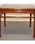 Rectangular wood coffee or side table with straight legs, positioned against a plain wall and floor.