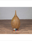 Mustard yellow ceramic vase with tapered spout on wooden floor, color card in front.