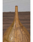 Mustard yellow ceramic vase with tapered spout on wooden surface.