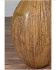 Close-up of mustard ceramic vase with tapered spout on wooden floor.